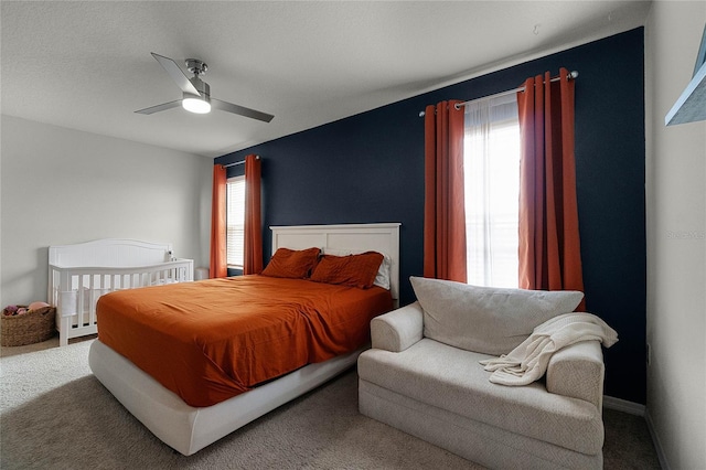 bedroom featuring multiple windows, ceiling fan, and carpet