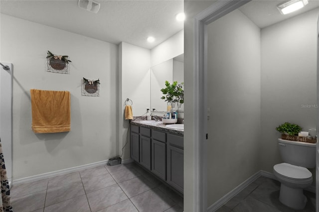 bathroom with tile patterned flooring, vanity, and toilet