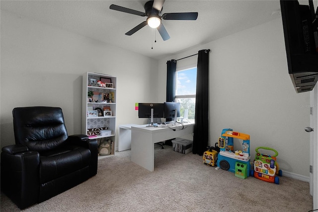 carpeted home office featuring ceiling fan