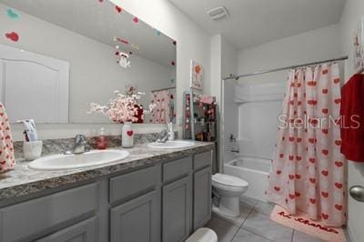 full bathroom featuring toilet, vanity, tile patterned flooring, and shower / tub combo with curtain