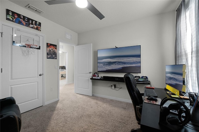 carpeted home office with ceiling fan and a textured ceiling