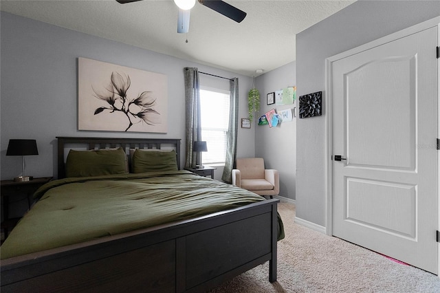 bedroom with a textured ceiling, ceiling fan, and carpet