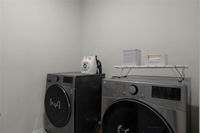 clothes washing area with washer and clothes dryer