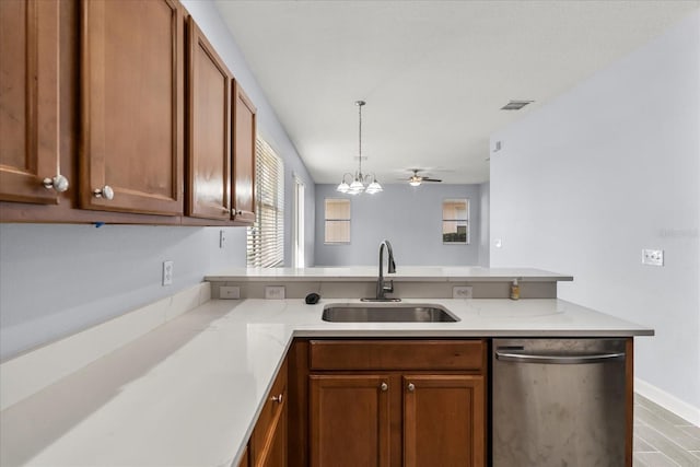 kitchen with ceiling fan with notable chandelier, kitchen peninsula, stainless steel dishwasher, and sink