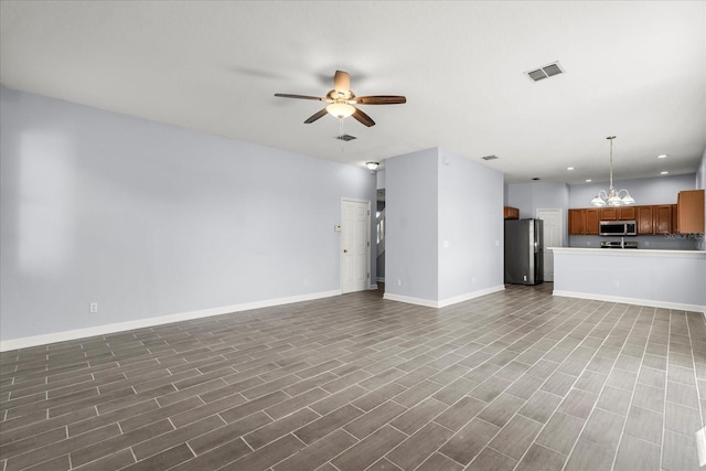 unfurnished living room featuring ceiling fan with notable chandelier