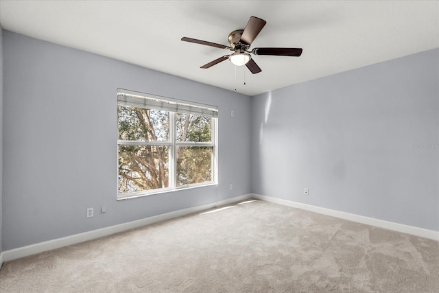 carpeted spare room featuring ceiling fan