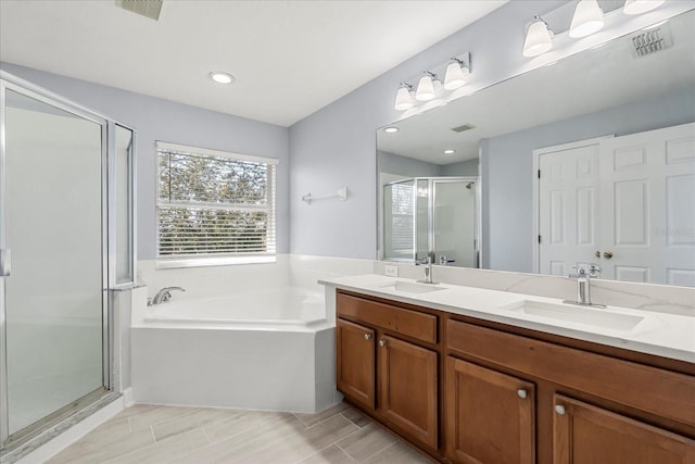 bathroom featuring shower with separate bathtub and vanity