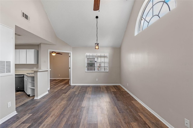 unfurnished dining area featuring dark wood-type flooring and high vaulted ceiling