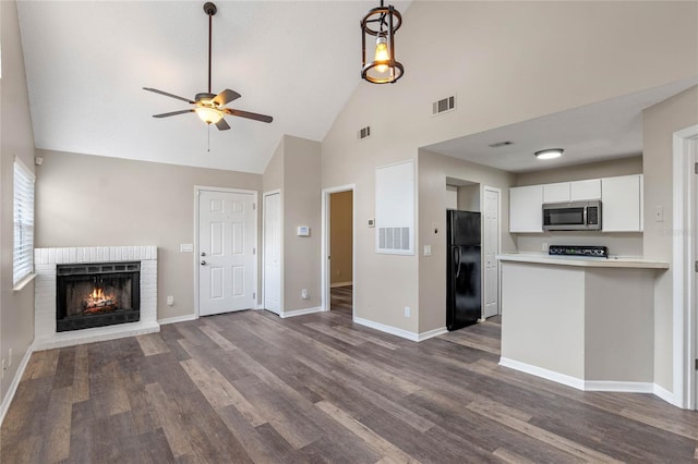 unfurnished living room featuring a brick fireplace, high vaulted ceiling, ceiling fan, and dark hardwood / wood-style flooring