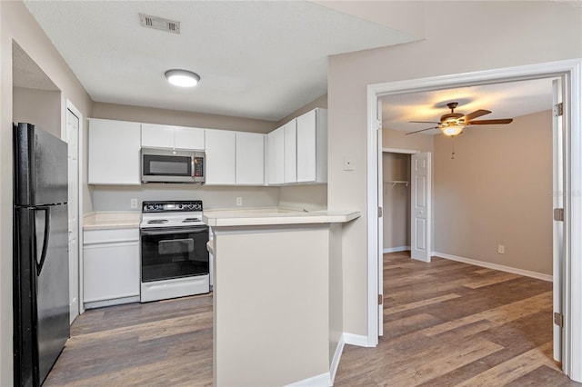 kitchen featuring white cabinetry, white electric stove, black fridge, ceiling fan, and dark hardwood / wood-style flooring