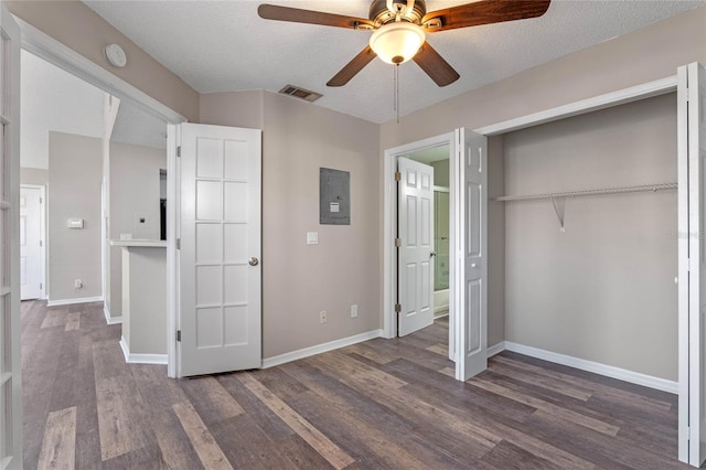 unfurnished bedroom featuring a textured ceiling, electric panel, ceiling fan, a closet, and dark hardwood / wood-style floors