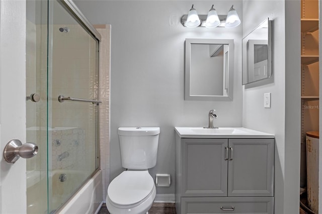 full bathroom featuring bath / shower combo with glass door, vanity, and toilet