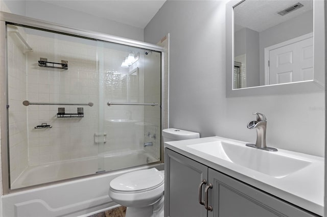 full bathroom with toilet, combined bath / shower with glass door, and vanity