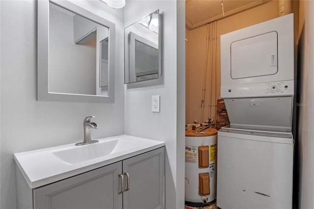 washroom featuring stacked washer and dryer, water heater, and sink