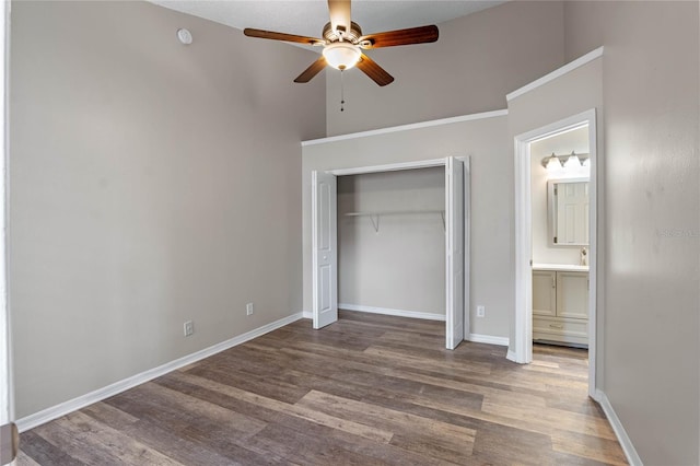 unfurnished bedroom featuring ensuite bathroom, a closet, ceiling fan, and hardwood / wood-style flooring