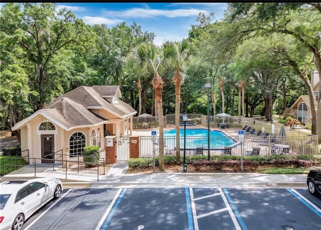 605 Youngstown Pkwy Unit 32, Altamonte Springs, FL 32714 - exterior space featuring fence, uncovered parking, a swimming pool, and view of wooded area