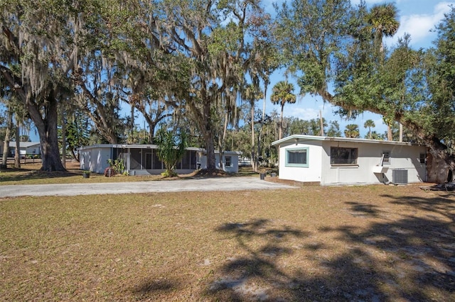 view of yard featuring central air condition unit and a sunroom