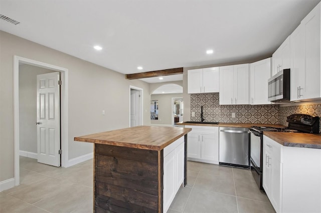 kitchen with butcher block counters, backsplash, white cabinetry, appliances with stainless steel finishes, and sink