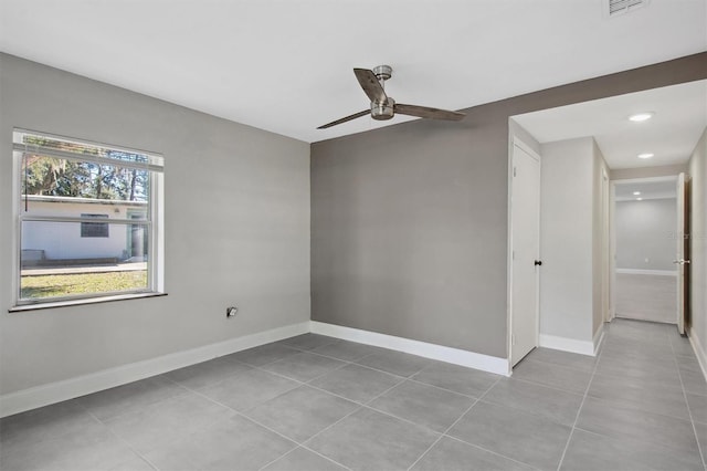 tiled spare room with ceiling fan