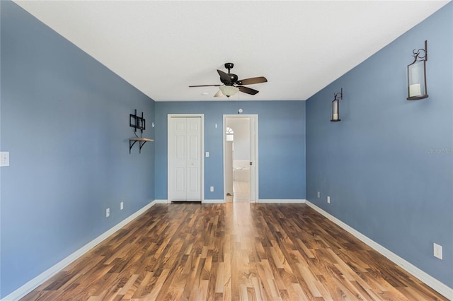 unfurnished room with ceiling fan and dark hardwood / wood-style flooring