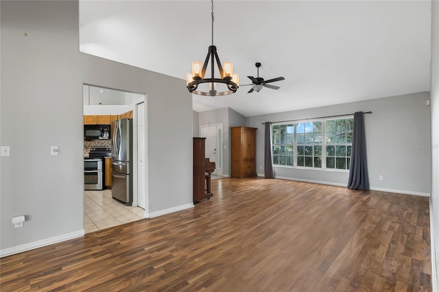 unfurnished living room with lofted ceiling, light wood-type flooring, and ceiling fan with notable chandelier