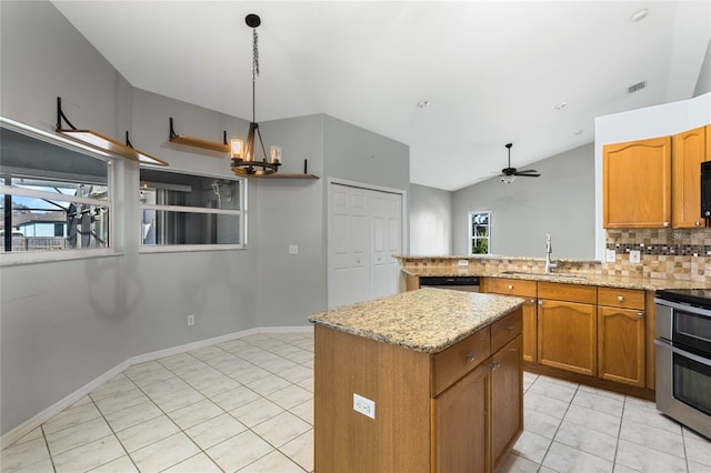 kitchen featuring decorative light fixtures, vaulted ceiling, decorative backsplash, sink, and range with two ovens