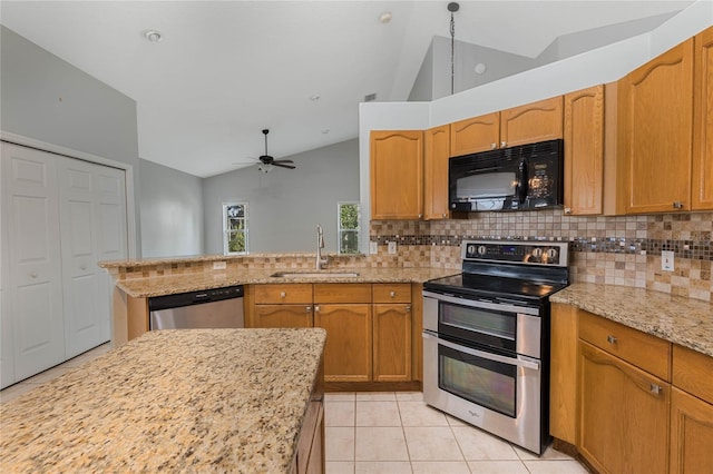 kitchen with lofted ceiling, stainless steel appliances, sink, backsplash, and light stone counters