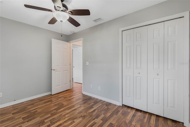 unfurnished bedroom featuring ceiling fan, dark hardwood / wood-style flooring, and a closet