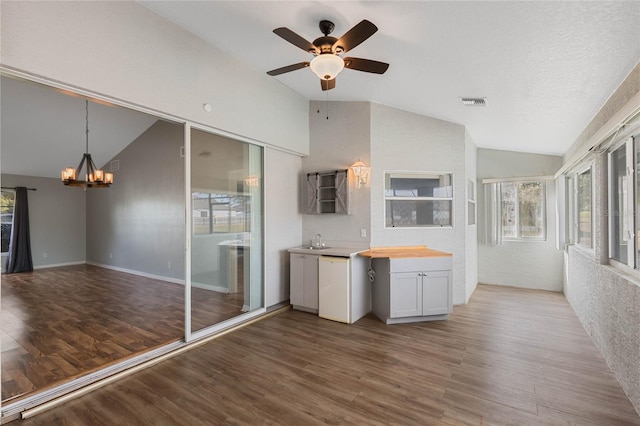 kitchen with hardwood / wood-style flooring, white cabinetry, and lofted ceiling