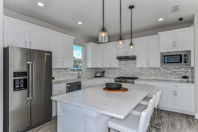 kitchen featuring appliances with stainless steel finishes, white cabinetry, and a kitchen island