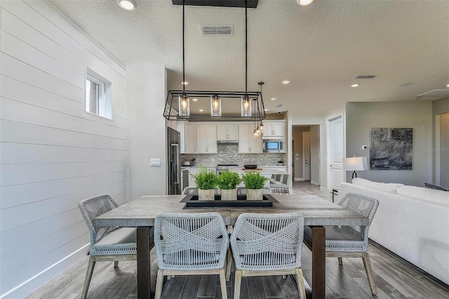 dining area featuring hardwood / wood-style floors and a textured ceiling