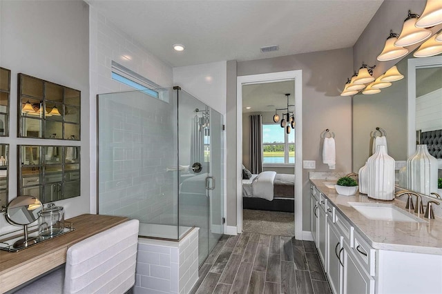 bathroom with vanity, a notable chandelier, and a shower with door