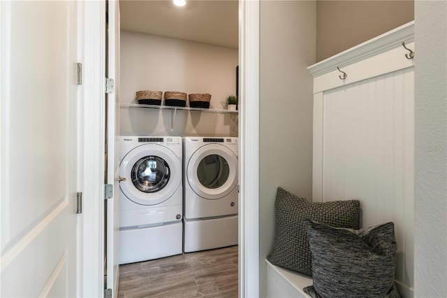 clothes washing area featuring wood-type flooring and independent washer and dryer