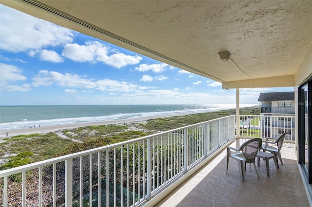 balcony with a water view and a beach view