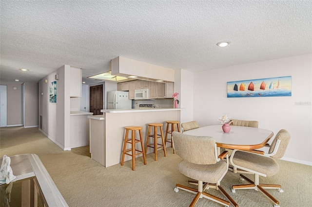 dining space with light colored carpet and a textured ceiling