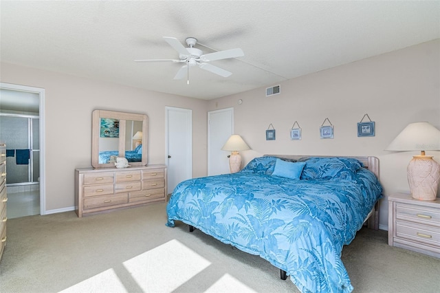 carpeted bedroom with ceiling fan, ensuite bath, and a textured ceiling