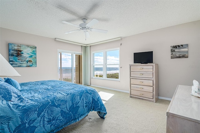 bedroom featuring light carpet, ceiling fan, a textured ceiling, and access to outside