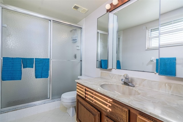 bathroom featuring an enclosed shower, vanity, toilet, and tile patterned flooring