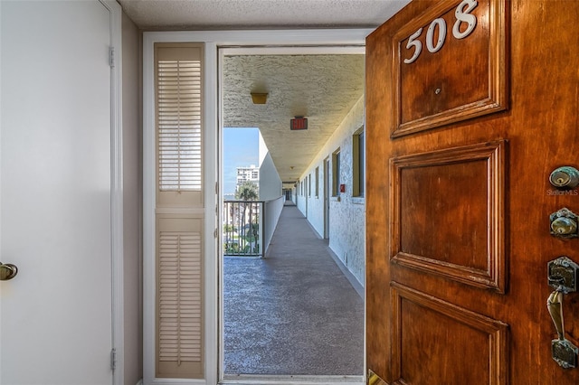 hallway with carpet and a textured ceiling