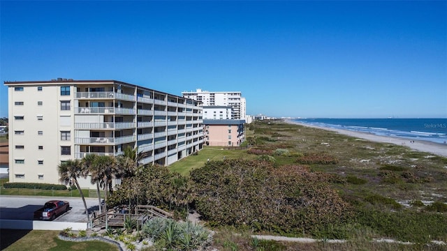 view of building exterior with a water view and a view of the beach