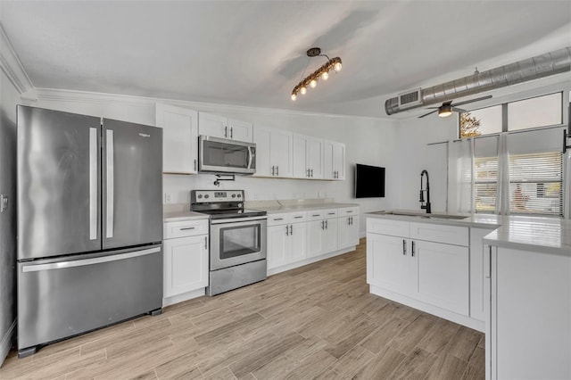 kitchen with white cabinetry, ceiling fan, stainless steel appliances, ornamental molding, and sink