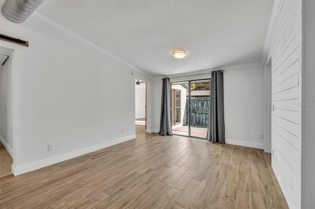 spare room featuring crown molding and light wood-type flooring