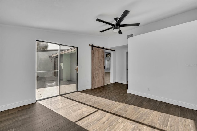 unfurnished room featuring ceiling fan, a barn door, and vaulted ceiling