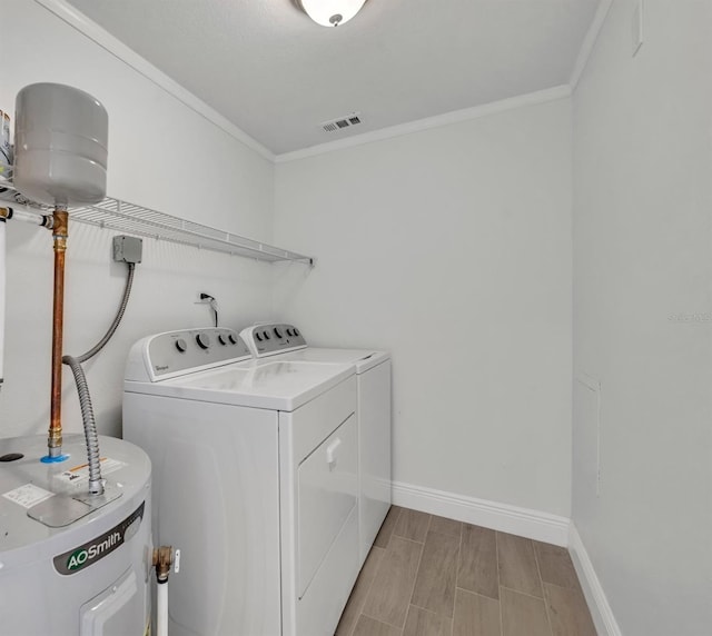 laundry area featuring electric water heater, washing machine and dryer, and ornamental molding