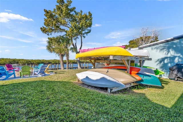 view of playground with a water view and a lawn