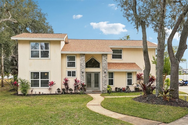 view of front of property with a front yard and french doors