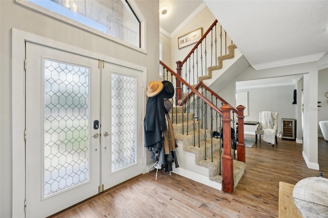 foyer featuring ornamental molding, a textured ceiling, and hardwood / wood-style flooring