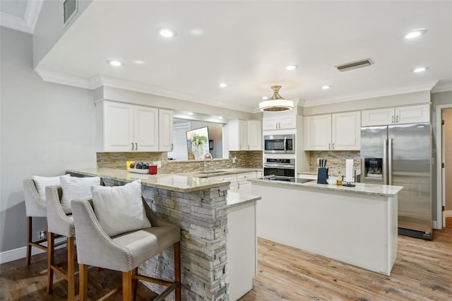 kitchen with sink, white cabinets, a center island, and stainless steel appliances