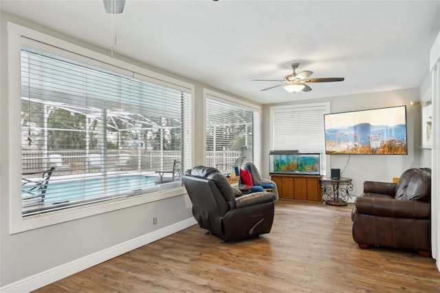 living room featuring ceiling fan, hardwood / wood-style floors, and a healthy amount of sunlight