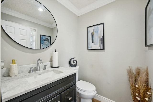 bathroom featuring toilet, vanity, and ornamental molding